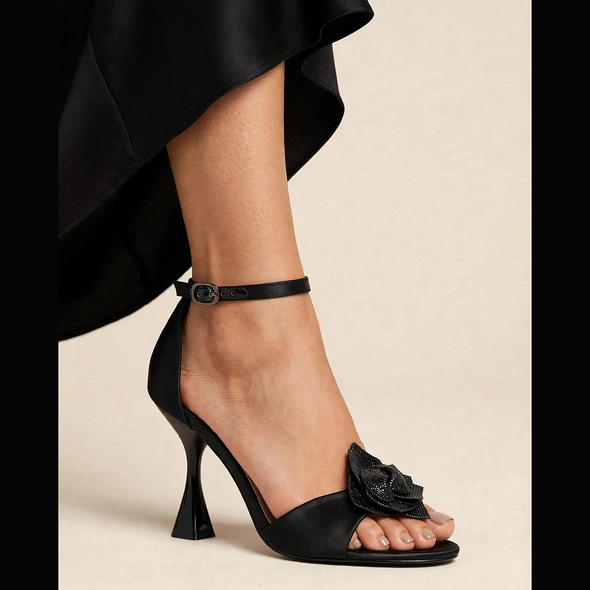 Fleur Crystal Sandal in black - satin sandal with crystal flower applique and sculptural heel, worn on foot