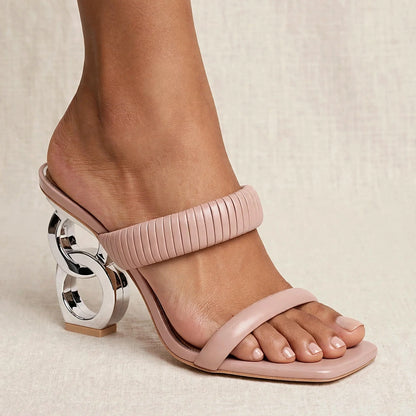 Goddess Nude mule sandals with sculptural silver heel worn on model