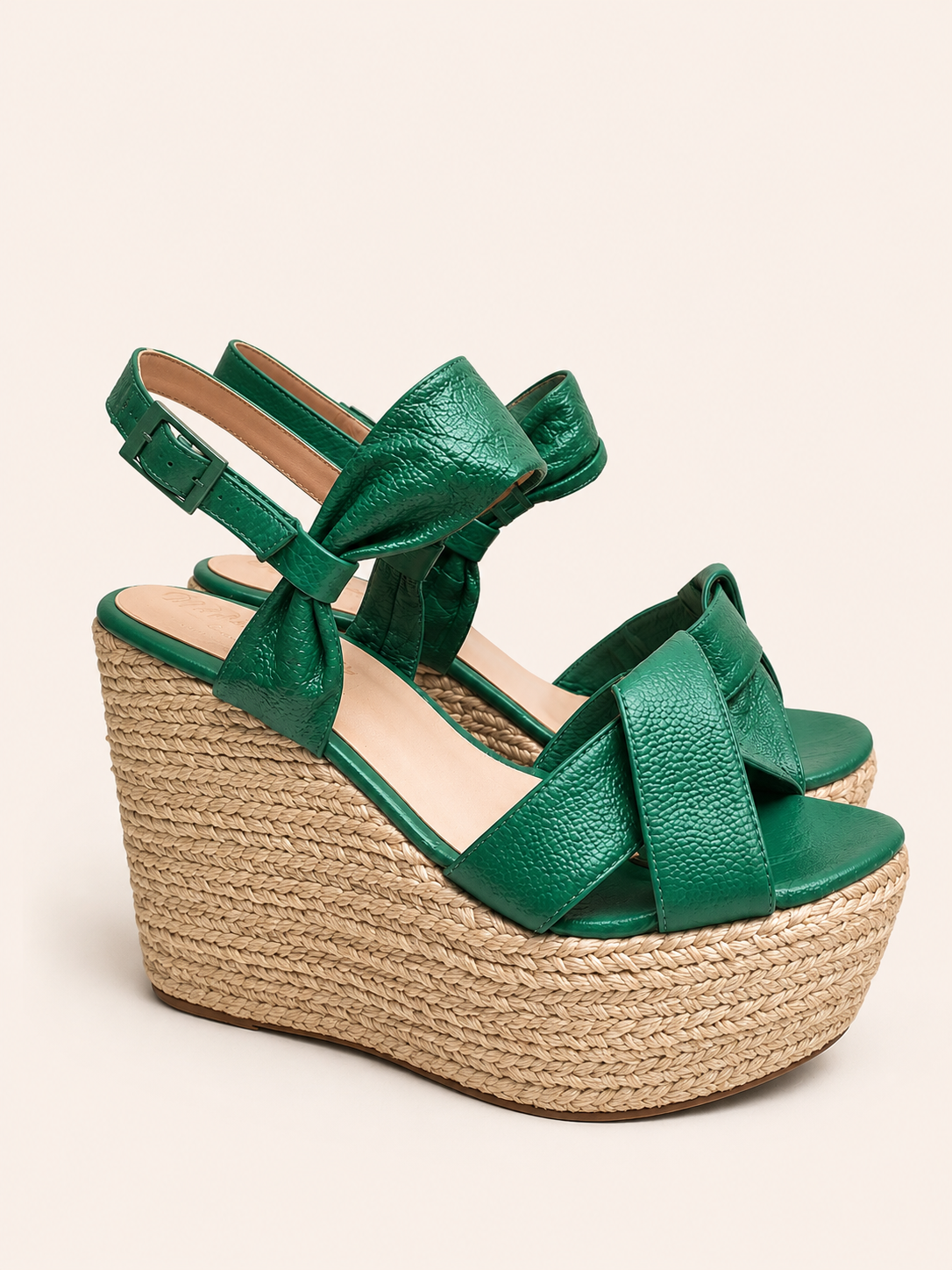 Savannah green leather espadrille wedge sandals with crossover straps, statement ankle bow, adjustable buckle, open toe design, and natural jute platform.
